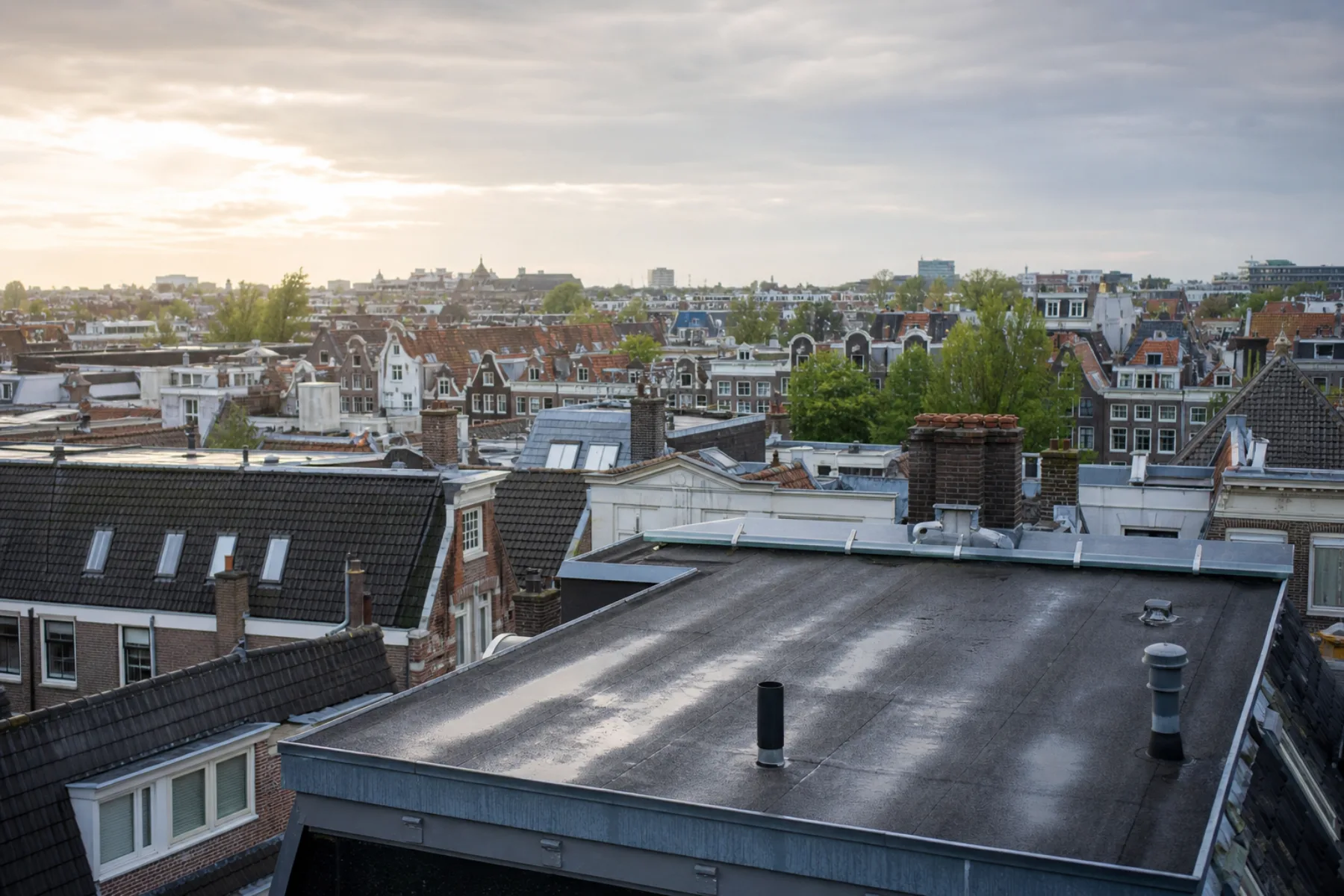 Platte en hellende daken in Amsterdam na een regenbui
